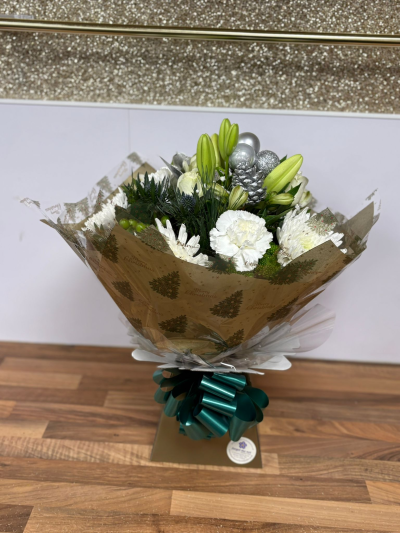 Frosted Elegance Hand-Tied Bouquet - A stylish winter hand-tied bouquet with white lilies, roses, carnations, chrysanthemums and festive silver accents. Beautifully wrapped and delivered in water by your local florist