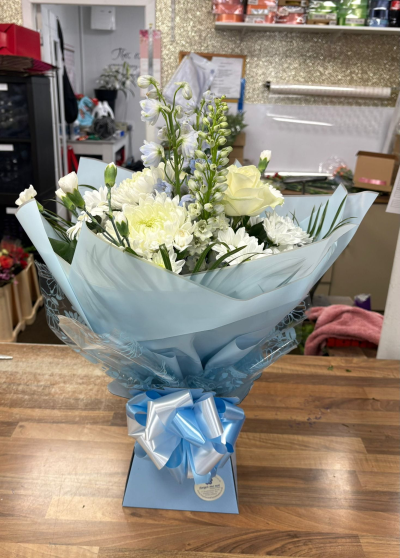 Baby Boy - Elegant white flowers presented in beautiful blue wrapping with a stylish bow, creating a thoughtful and charming gift to celebrate a new baby boy.