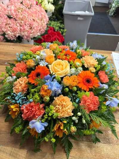 Vibrant Peach & Orange Posy - Bright and uplifting posy arrangement in warm peach, orange and soft pastel tones, thoughtfully designed for remembrance and tribute.