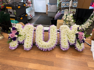 Mum Letter Tribute - Elegant floral letter tribute in soft white and lilac tones, lovingly designed to honour and remember a cherished mum.