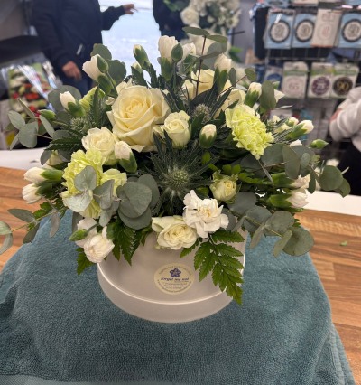Ivory Elegance Hatbox - Elegant ivory hatbox arrangement with white roses, soft carnations and textured foliage for a sophisticated floral gift.